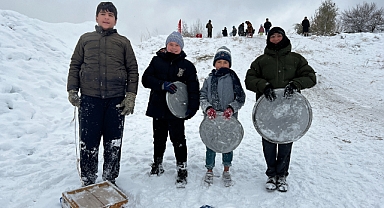 Çocuklar, fırın tepsisi, leğen, poşet ve kızakla kaydı